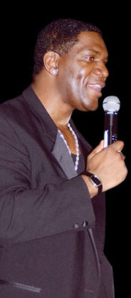 Howard holding a microphone on stage